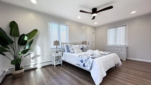 A bedroom with a bed, bedside tables, a ceiling fan, and a potted plant. - 1BR Apt | High Speed WiFi | Washer/Dryer | Coffee (Seaside Heights)
