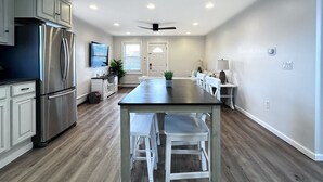 A modern kitchen with a central island, stainless steel appliances, and a ceiling fan. - 1BR Apt | High Speed WiFi | Washer/Dryer | Coffee (Seaside Heights)