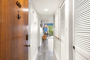 A hallway with a wooden door, white walls, and a window with a view. - Xanadu Retreat - Near Coligny (Hilton Head Island)