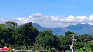 A mountainous landscape with dense greenery and a clear sky.