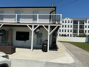 Ein Gebäude mit Balkon, Fernseher und Mülleimer.
