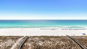 A beach with a wooden boardwalk, white sand, and a clear blue sky. - Fully remodeled ocean front condo with views, pool (Navarre)