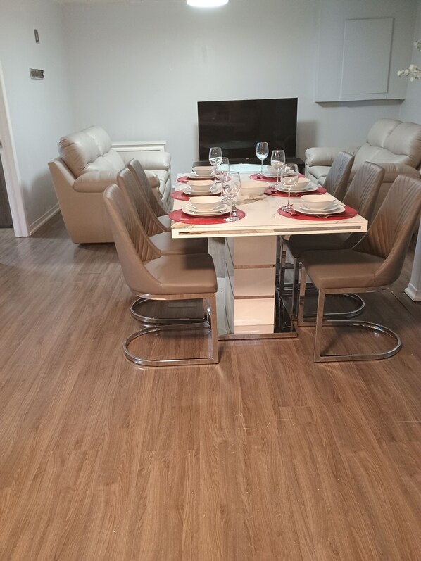 A dining area with a table set for four, surrounded by leather chairs.