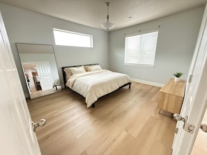 A bedroom with a bed, a wooden dresser, a mirror, and a window with blinds. - 3-bedroom house in marvelous Battle Ground (Battle Ground)