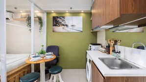 Una cocina compacta con lavamanos, encimera y armarios de madera.