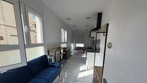 Un intérieur moderne avec un canapé bleu, un coin cuisine et un espace repas.