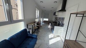 Une cuisine moderne avec un coin repas, un canapé et une vue sur l’extérieur.