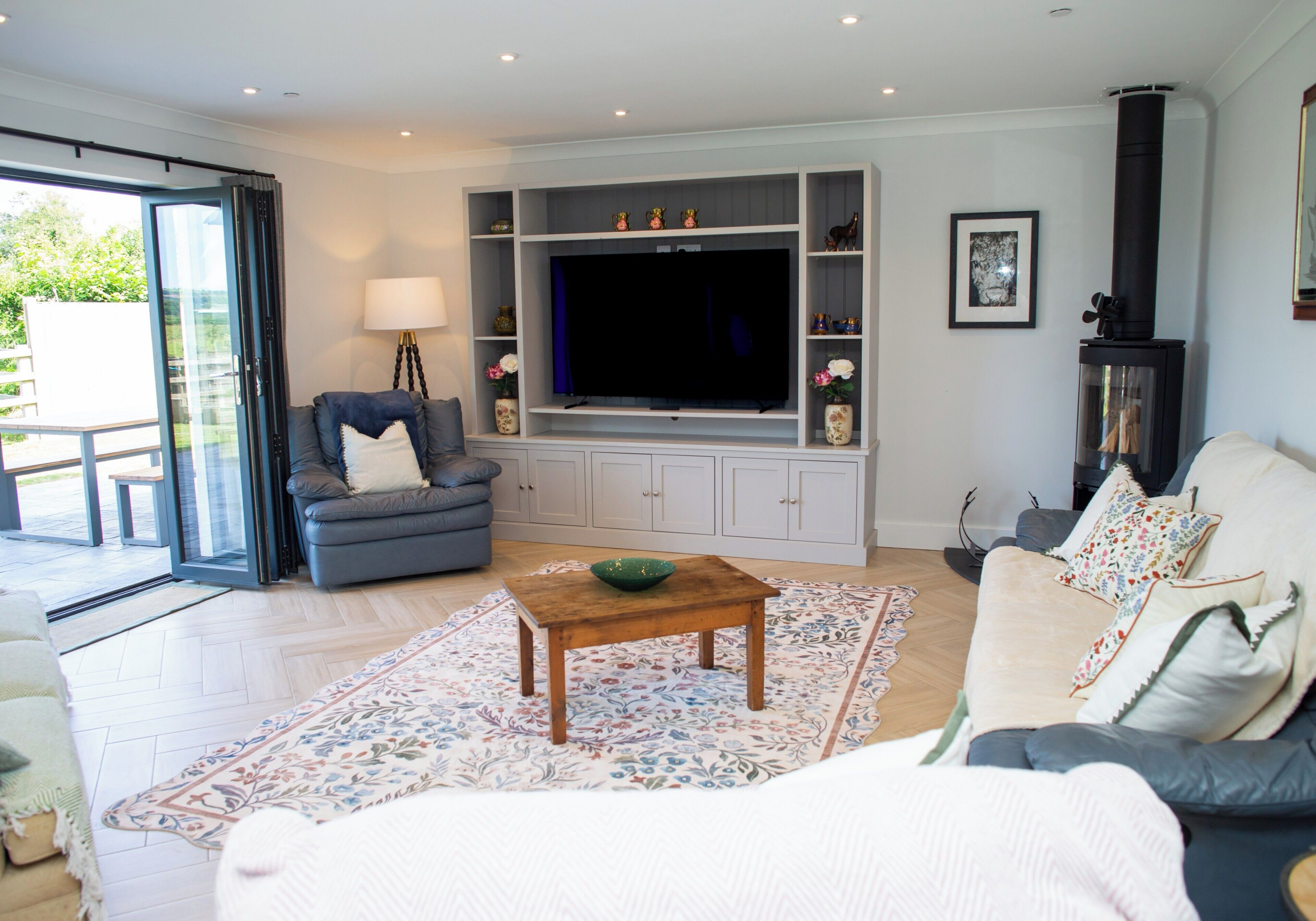 A living room with a sofa, a coffee table, a TV, and a fireplace.