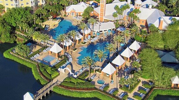 A resort with multiple swimming pools, palm trees, and a dock. - 1 Bedroom Condo, Sleeps 4, SeaWorld Hilton Grand Vacations (Orlando)