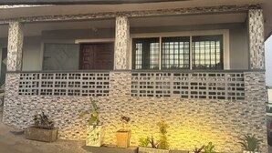 Un edificio con fachada de ladrillo, una puerta de madera y varias ventanas con rejas metálicas.