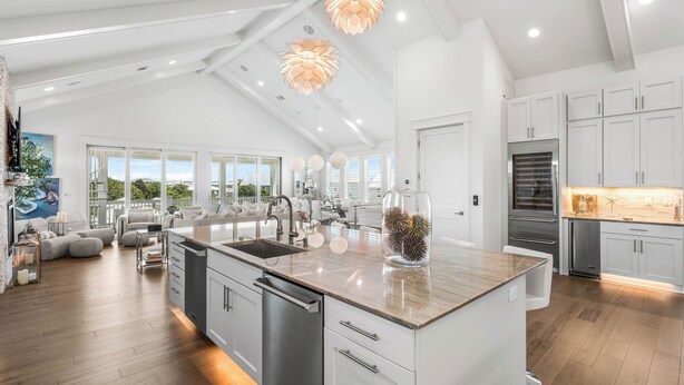 A spacious kitchen with a large island, white cabinetry, and modern pendant lighting. - Sugar Magnolia: Close to beach in Grayton w/ Pool!  4 Kings + 6 Bunks; sleeps 14 (Santa Rosa Beach)