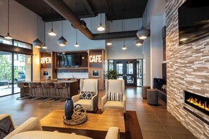 A modern cafe with a bar area, comfortable seating, and a fireplace. - Brand New Fully Furnished 2 Bed 2 Bath Luxury Condo with Gym & Pool By Stanford (Menlo Park)