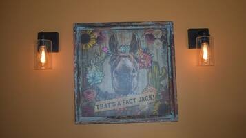 A wall-mounted artwork with a dog and text, flanked by two wall-mounted light fixtures.