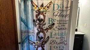Una habitación con una puerta y una cortina decorativa que muestra un burro y un texto inspirador.