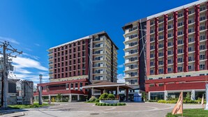 Un hotel moderno con varios pisos, un patio central y una entrada cubierta.