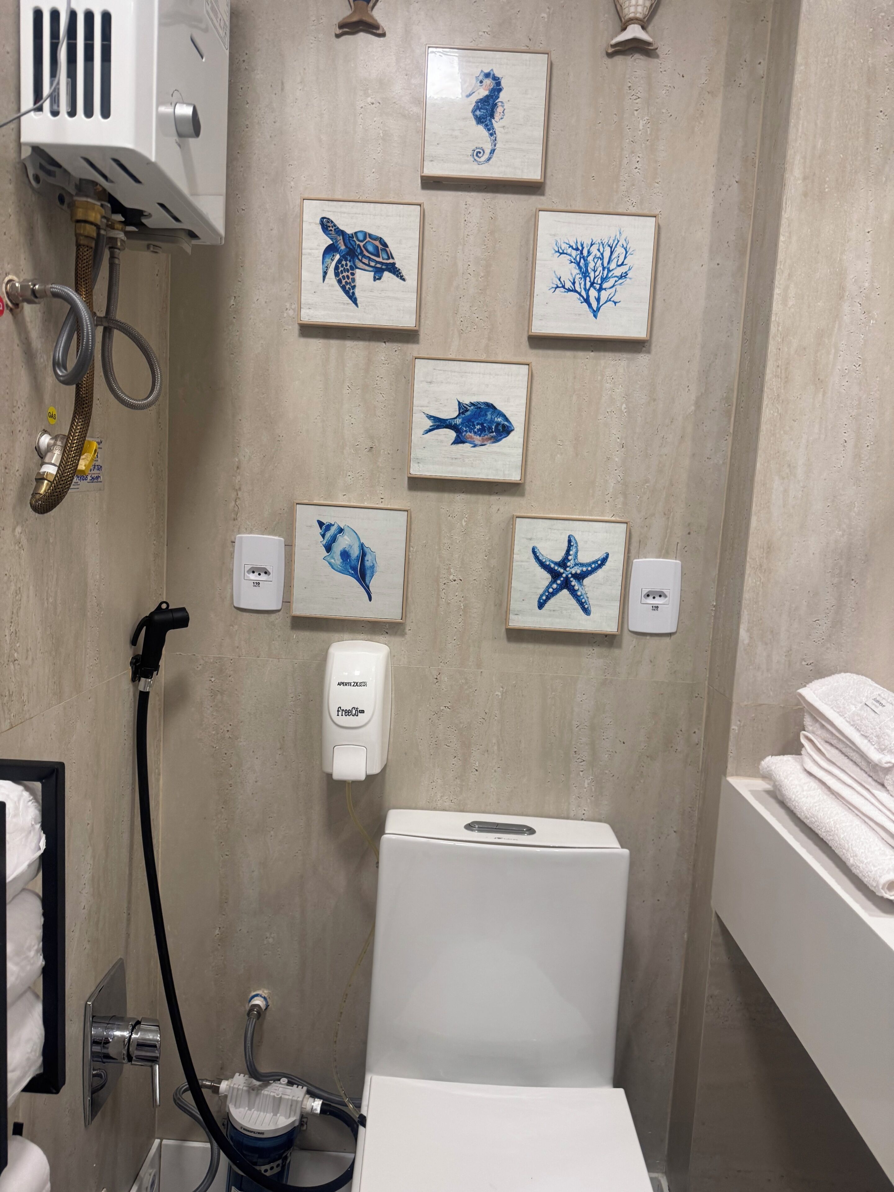 Une salle de bain équipée d’une douche, de toilettes, d’un lavabo et d’un porte-serviettes.