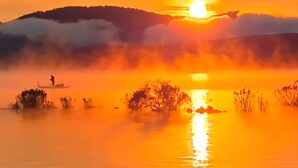 A sunset over a calm body of water with a silhouette of a hill in the background. - Cozy 1-bedroom private cabin  with AC and heat. Minutes to Sacanadaga Lake (Broadalbin)