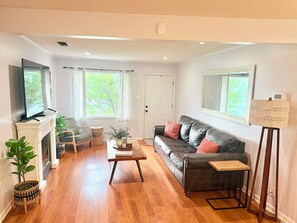 A living room with a fireplace, a sofa, a coffee table, and a television.