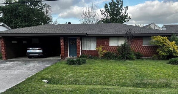 A residential house with a garage, a front lawn, and a driveway.