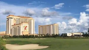 Ein Hotel mit mehreren Hochhäusern, einem Golfplatz und blauem Himmel.