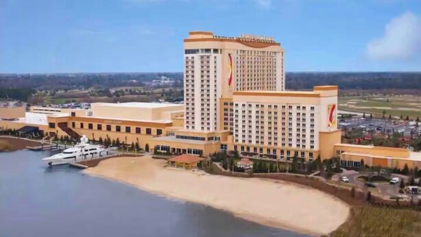 Ein großes Hotel mit mehreren Gebäuden, einer Marina und einem Strand.