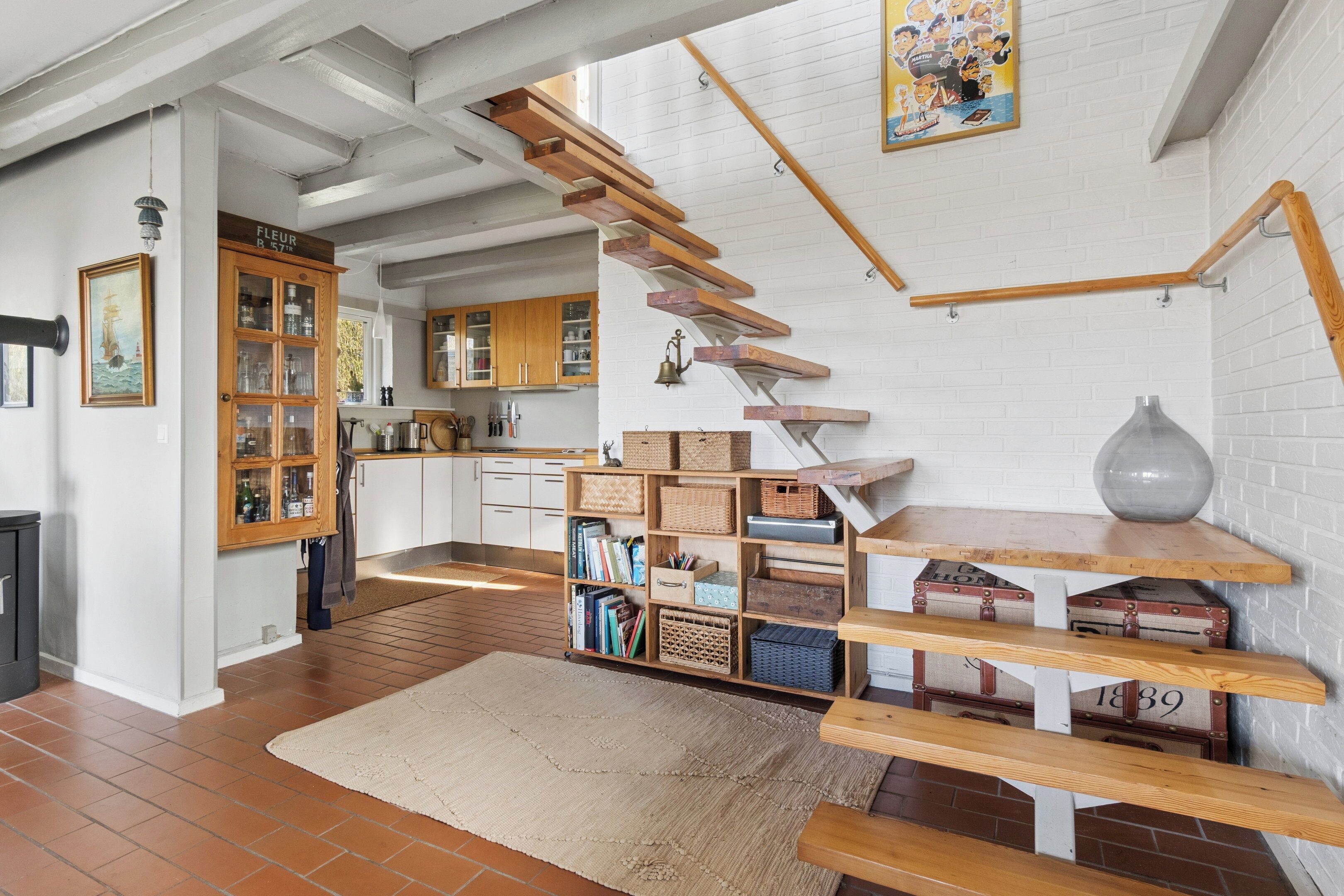Une cuisine spacieuse avec des meubles en bois, un escalier et un tapis au style rustique.