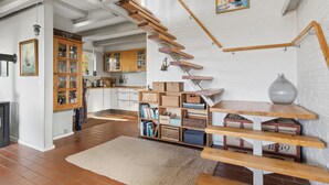 Un'ampia cucina con mobili in legno, una scala e un tappeto rustico.