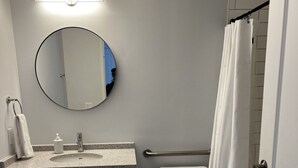A bathroom with a toilet, sink, mirror, and shower curtain.