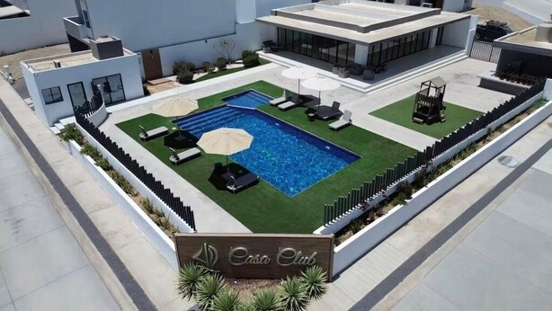 A modern hotel with a rooftop pool, lounge chairs, and a sign reading 'Casa Club.' - Modern house with 3 bedrooms, pool, La Paz BCS (La Paz)