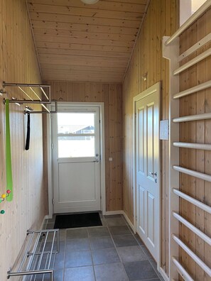 A wooden interior hallway with a door, a metal rack, and a view through the door. - Cozy holiday home in Vejlby Klit (Harboøre)