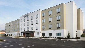 A multi-story hotel with a flat facade, a parking lot in front, and a sign indicating 'STUDIOS.' - StudioRes by Marriott Louisville East (Louisville)