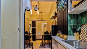 Una cocina moderna con un lavamanos, encimera y comedor con sillas y una mesa.