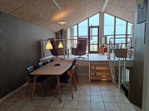 A modern meeting room with a large table, chairs, and a view through large windows. - Holiday home near forest and beach (Egernsund)