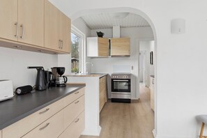A modern kitchen with wooden cabinets, a built-in oven, and a coffee maker. - Active holiday in large home with garden (Vig)