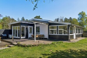 A modern house with a patio, a covered outdoor seating area, and a large windowed room. - Active holiday in large home with garden (Vig)