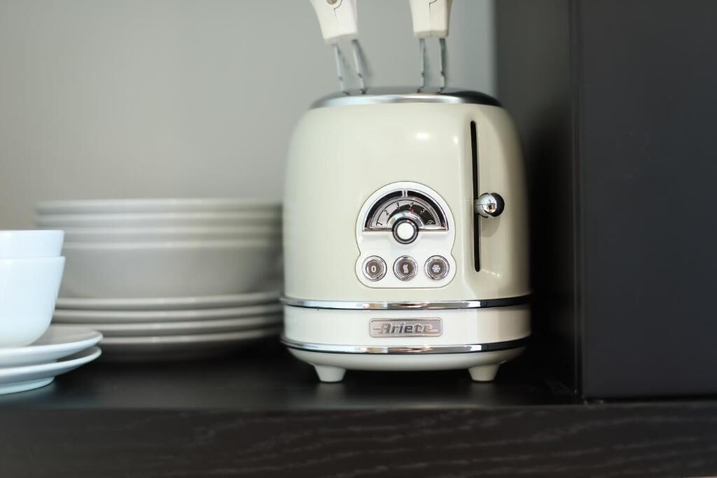 Eine Küche mit einem weißen Gerät, möglicherweise einem Toaster, und gestapelten weißen Tellern.