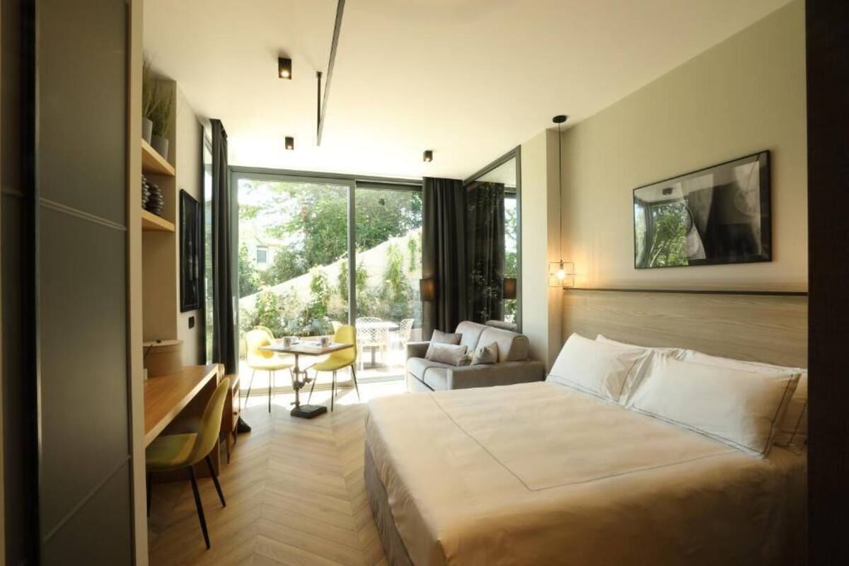 Une chambre d’hôtel moderne dotée d’un grand lit, d’un bureau et d’un coin repas avec des chaises.