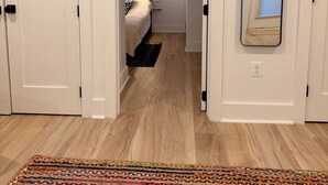 A hallway with a bed, a mirror, and a colorful rug. - Light-Filled Lower Suite · Brand New · Private · 5 Mins to Metro · Parking (Washington)