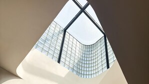 A modern building with a curved facade and a glass section. - EMA Condesa (Mexico City)