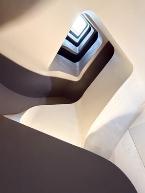 A modern architectural design with smooth, flowing lines and a central geometric pattern. - EMA Condesa (Mexico City)