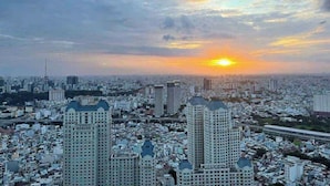 A cityscape with high-rise buildings, a sunset, and a dense urban environment. - Vinhomes central park  (Ho Chi Minh City)