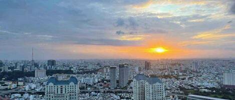 Un horizonte urbano con edificios altos, un atardecer y un entorno metropolitano denso.