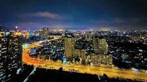A nighttime cityscape with illuminated buildings and a busy highway. - Vinhomes central park  (Ho Chi Minh City)