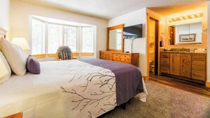 Une chambre à coucher avec un lit, une commode, un miroir et une fenêtre.