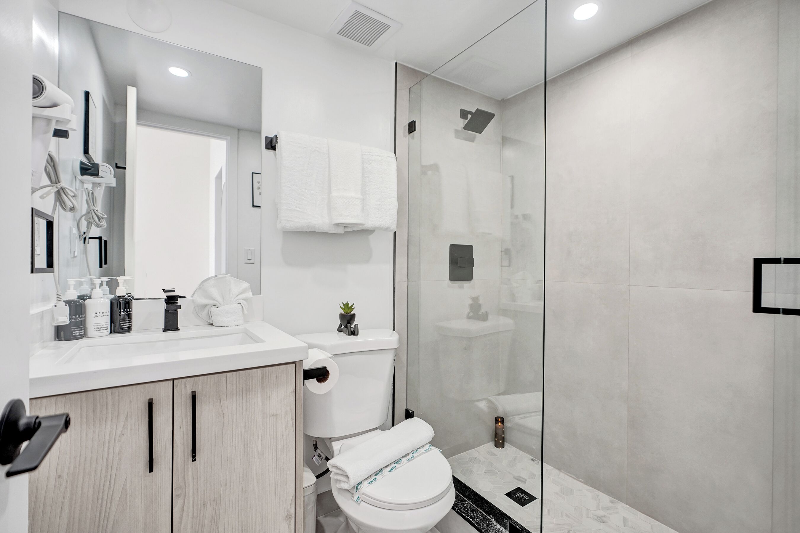 Ein modernes Badezimmer mit Toilette, Waschbecken und Duschbereich.