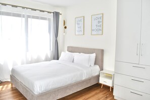 Ein Schlafzimmer mit einem Bett, einem Nachttisch, einem Kleiderschrank und zwei Wandbildern mit motivierenden Sprüchen.