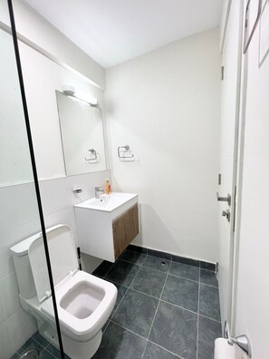 Ein Badezimmer mit Toilette, Waschbecken und Spiegel.