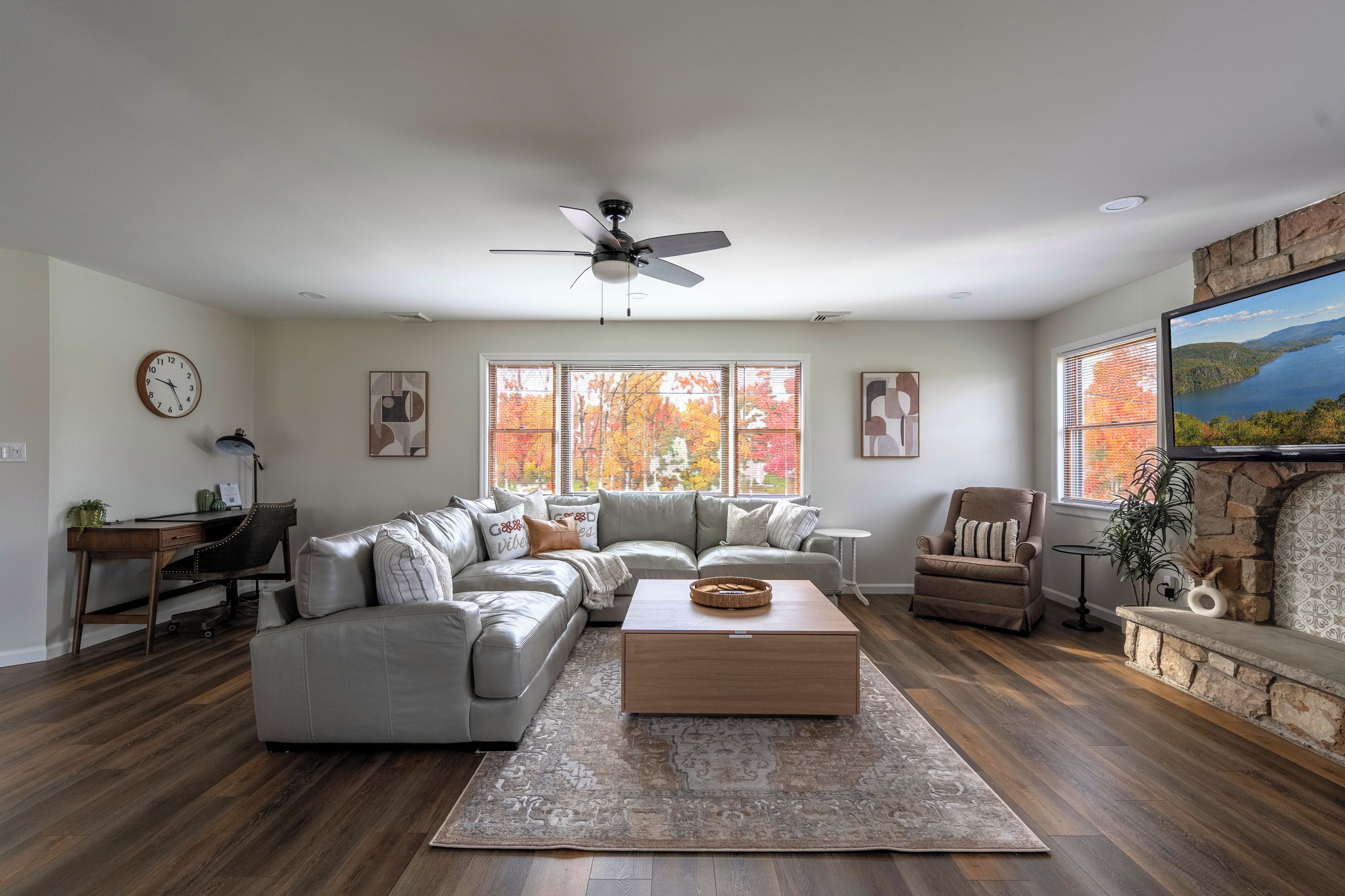 A spacious living room with a large sectional sofa, a coffee table, a fireplace, and a television.