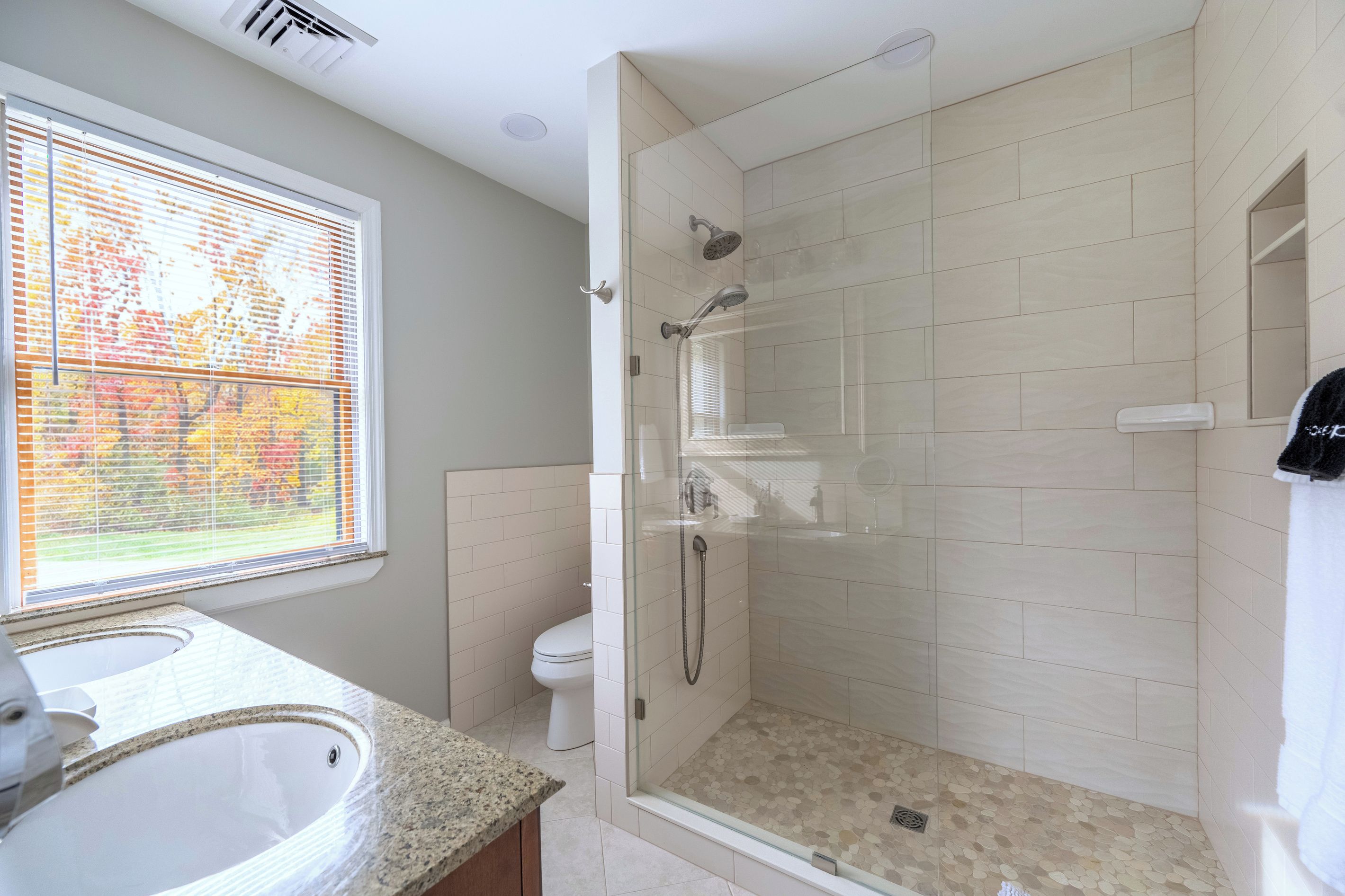 A modern bathroom with a shower, toilet, and sink.