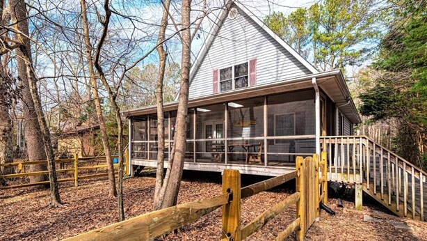 A cabin with a deck, surrounded by trees. - Spacious A-Frame Family Beach Getaway - Sleeps 8 (Ocean Pines)